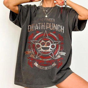 Op de afbeelding: Donkergrijs t-shirt met de bandnaam "Five Finger Death Punch" in wit en rood. Het ontwerp bevat een ster en een boksbeugel-afbeelding met de tekst "Las Vegas - Nevada".