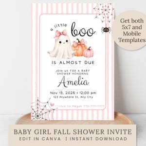 May include: A rectangular baby shower invitation card featuring a white background with vertical light pink stripes. The design includes a watercolor ghost with a pink bow, two orange and pink pumpkins, and black spiderwebs with a small spider.