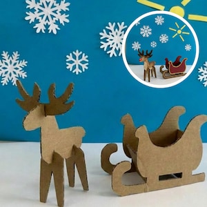 Puede incluir: Juego de renos y trineos de cartón sobre un fondo azul con recortes de copos de nieve blancos. El reno tiene cuernos marrones y una nariz roja. El trineo es marrón con el interior rojo. Decoración festiva navideña.