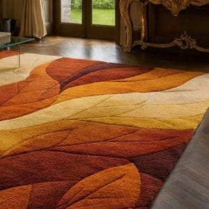 The rug appears thick and plush, suggesting a soft wool or high-quality synthetic pile that provides comfort underfoot. Its generous size anchors the seating area, making it suitable for living rooms, formal lounges, bedrooms, or stylish family spaces. The sculpted carving technique adds depth and luxury appeal, while the autumn-inspired palette creates a warm, inviting atmosphere.
Overall, this abstract leaf area rug functions as both a practical floor covering and a bold design centerpiece.