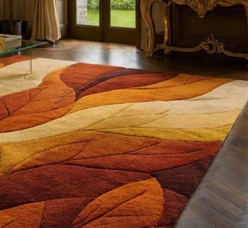 The rug appears thick and plush, suggesting a soft wool or high-quality synthetic pile that provides comfort underfoot. Its generous size anchors the seating area, making it suitable for living rooms, formal lounges, bedrooms, or stylish family spaces. The sculpted carving technique adds depth and luxury appeal, while the autumn-inspired palette creates a warm, inviting atmosphere.
Overall, this abstract leaf area rug functions as both a practical floor covering and a bold design centerpiece.