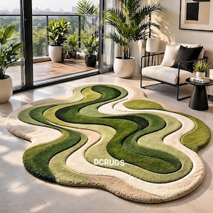 May include: A unique, abstract area rug with a wavy design in shades of green, cream, and beige. The rug's irregular shape and color palette create a modern, organic feel. The text "DCRUGS" is visible on the rug.