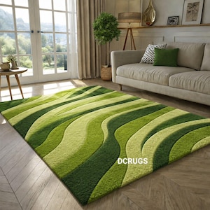 May include: A rectangular green area rug with a wavy pattern in shades of green. The rug is placed on a hardwood floor in a living room setting. The text "DCRUGS" is visible on the rug.