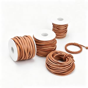 Puede incluir: Tres carretes de plástico blanco envueltos con cordón de cuero color canela plano, una bobina suelta de cordón de cuero color canela y una pulsera de cuero trenzado color canela con un pequeño cierre de nudo. Los cordones son lisos y marrones.
