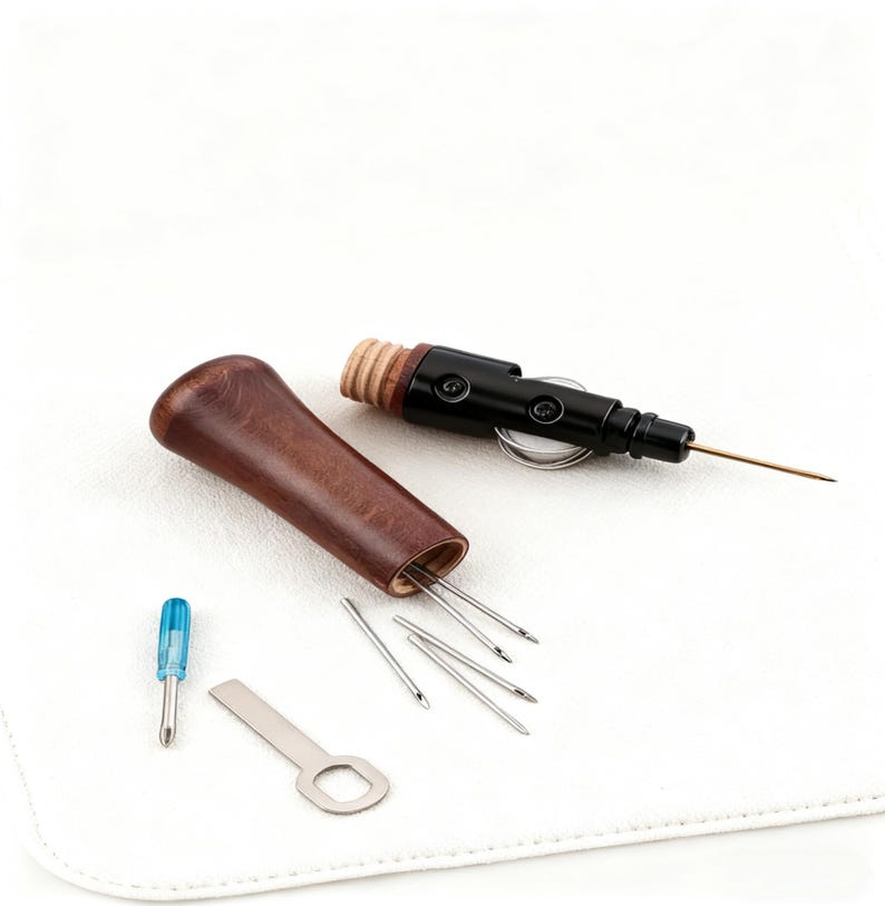 May include: A sewing kit with a dark brown wooden handle and a black metal needle holder. The kit includes needles, a small screwdriver, and a metal tool, all on a white surface.