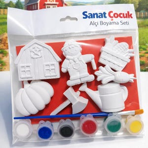 May include: A children's paint set with plaster farm figures, such as a barn, farmer, pumpkin, and watering can. The set includes a paintbrush and small paint pots with various colours. The packaging has the text "Sanat Çocuk Alçı Boyama Seti".