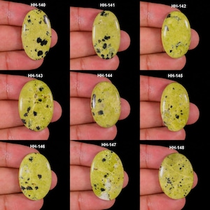 Peut inclure: Une collection de neuf cabochons de forme ovale présentant une couleur de base vert citron clair avec des inclusions noires dispersées. Chaque pierre est étiquetée individuellement avec des codes allant de HH-140 à HH-148.