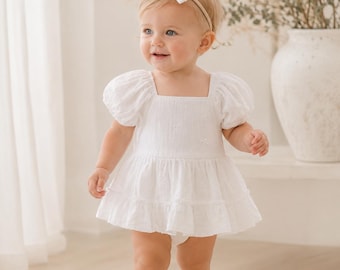 White eyelet baby girl dress romper with bow headband. Elegant blessing garment and flower girl outfit for infant dedication ceremony.