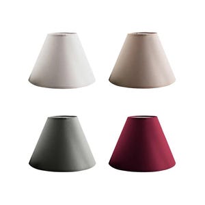 May include: Four tapered lampshades in cream, beige, grey, and burgundy. The shades have a classic cone shape, suitable for table or floor lamps. The shades are made of a smooth fabric. Each lampshade is a different colour.