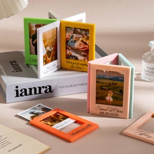 Peut inclure: Une collection de cadres photo rectangulaires en acrylique multicolore dans des tons vert citron, jaune, rose, bleu clair et orange. Les cadres sont articulés pour tenir debout ou être posés à plat, affichant des photos et des gravures personnalisées.