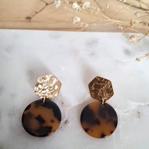 Puede incluir: Una taza de cerámica blanca con un asa negra y el texto "But first, coffee" en negro, con una fuente de estilo manuscrito. La taza está sobre una superficie blanca.