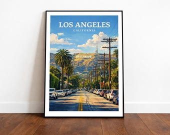 May include: Framed art print featuring a street scene in Los Angeles, California. The image shows a road lined with cars and palm trees, leading towards the Hollywood sign on a hillside under a blue sky. The words "LOS ANGELES CALIFORNIA" are at the top.