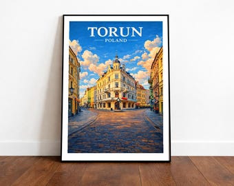 May include: Framed art print featuring a vibrant street scene in Torun, Poland. The artwork showcases a cobblestone street leading to a historic building under a bright blue sky with fluffy clouds. The word "TORUN" is displayed at the top.