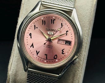 Vintage Seiko 5 automatisk herrarmbandsur med dag- och datumfunktion, rosa arabisk urtavla, nätrem