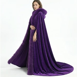 May include: A long, flowing purple velvet cloak with a hood and faux fur trim. The cloak features a dramatic train and is designed for formal wear or costume events. The rich color and luxurious texture create a regal appearance.