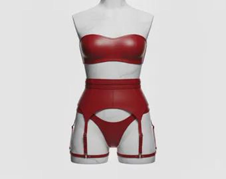 May include: A red faux leather lingerie set displayed on a white mannequin. The set includes a strapless bra, high-waisted garter belt, and matching underwear. The garter belt features suspender straps and metal hardware.