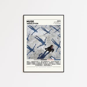 May include: A framed poster featuring the album art for Muse's "Absolution" album. The artwork shows a person surrounded by shadow figures. The poster includes the album title, year, and tracklist. The frame is black.