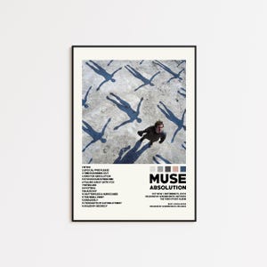Op de afbeelding: Een ingelijste poster met de albumhoes van Muse's "Absolution". De afbeelding toont een persoon die omhoog kijkt, omringd door schaduwfiguren. De albumtitel en tracklist staan in witte tekst.