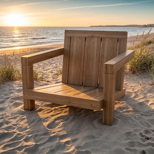 May include: A low-profile wooden armchair constructed from light brown planks, featuring a square frame, wide armrests, and a slatted backrest. The chair has a sturdy, blocky design with visible wood grain and a smooth, natural finish.
