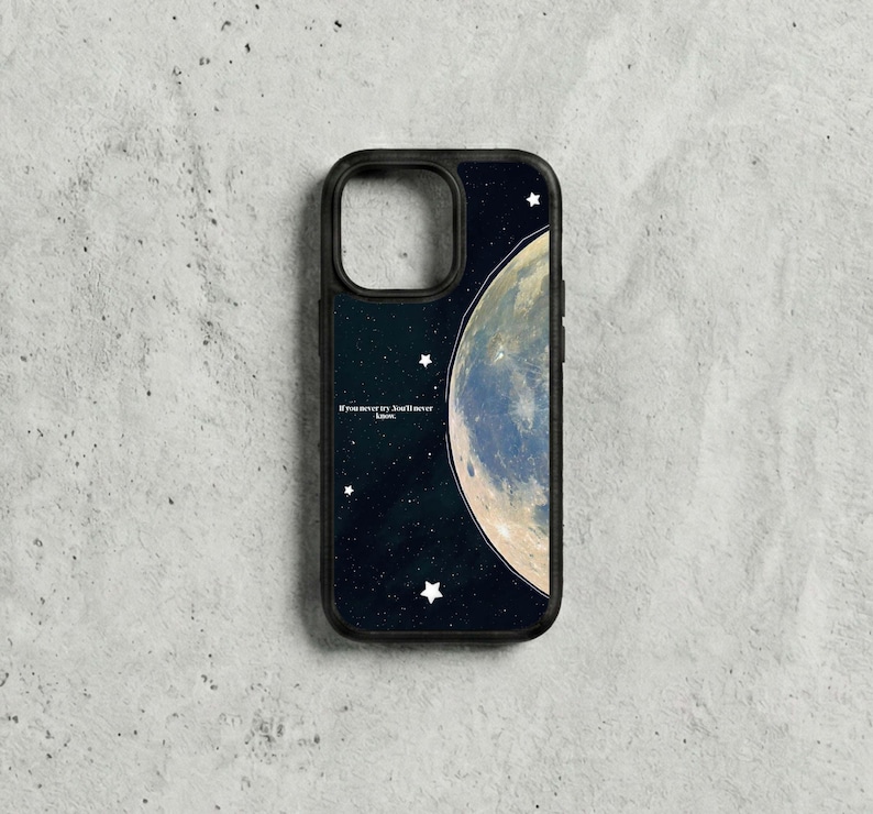 May include: Black phone case with a celestial design. It features a large moon and stars against a dark blue background. The case includes the text: "If you never try, you'll never know."
