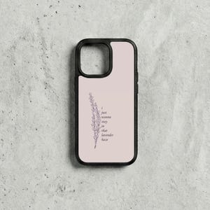 May include: A black phone case featuring a light pink backdrop and a lavender sprig illustration. The text "I just wanna stay in that lavender haze" is printed in dark purple. The case has a black border.