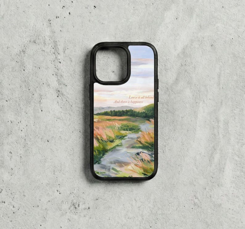 May include: Black phone case with a landscape painting of a river, fields, and trees under a sunset sky. The case has the text "Leave it all behind, And there is happiness."