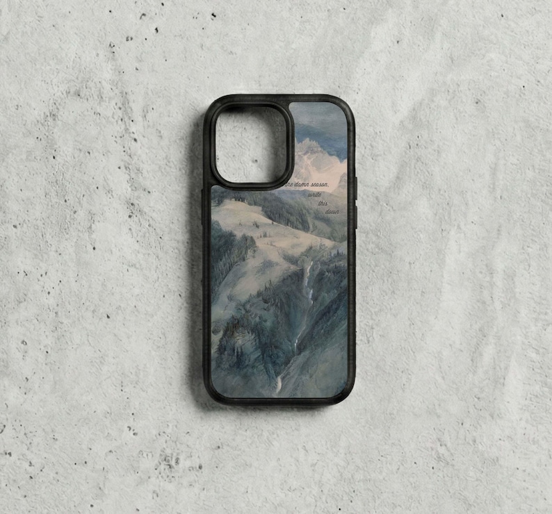 May include: Black phone case with a landscape painting of a mountain range and waterfall in shades of blue, green, and white. Text is visible on the upper right. The case has a black border.
