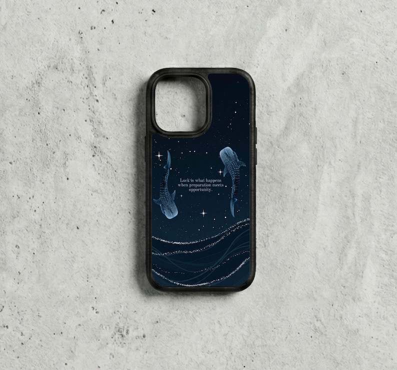 May include: Black phone case with a dark blue night sky design, two whale sharks, and the quote, "Luck is what happens when preparation meets opportunity." The case has a black border and a glossy finish.