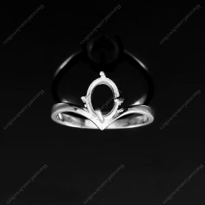 Peut inclure: Une monture de bague en métal argenté avec un anneau en forme de V et un sertissage central ovale à griffes conçu pour accueillir une pierre précieuse. L'objet est présenté sur un fond noir avec le texte HareemGemsJewellers répété en diagonale.