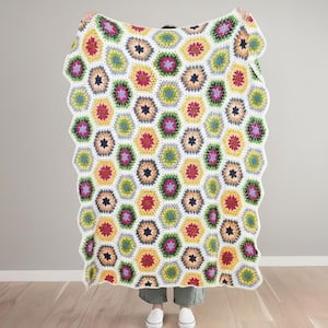 May include: A colorful, handmade crochet blanket with a honeycomb pattern. The blanket features a white scalloped edge and a repeating design of multi-colored hexagons in shades of yellow, pink, green, and blue.