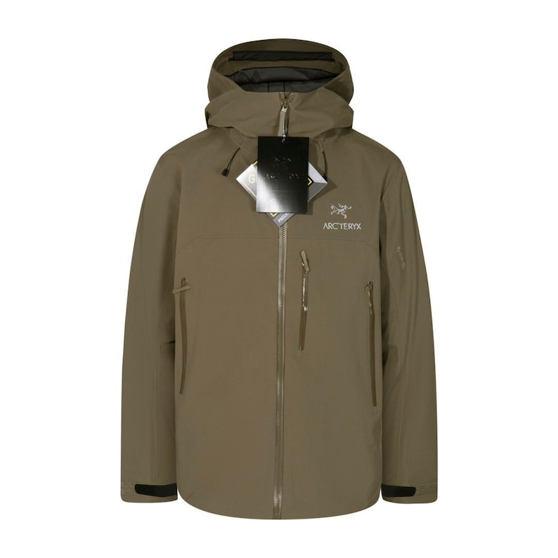 May include: A khaki-colored hooded jacket with a full-length zipper and multiple pockets. The jacket features the brand name "Arc'teryx" on the chest and a "GORE-TEX" tag. The jacket is designed for outdoor activities and protection from the elements.