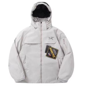 Może przedstawiać: Jasnoszara kurtka z kapturem i czarną podszewką. Kurtka posiada zamek błyskawiczny z przodu, kieszenie i małe logo na piersi. Z przodu naszyta jest naszywka "GORE-TEX".