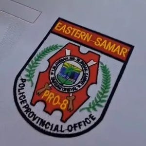 May include: A patch featuring the text "EASTERN-SAMAR" in orange on a black background. The patch has a red and white shield design with the text "POLICE PROVINCIAL OFFICE" and "PRO-8".