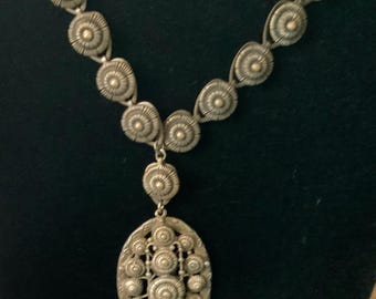 antique pendant necklace with a detailed circular teardrop design
