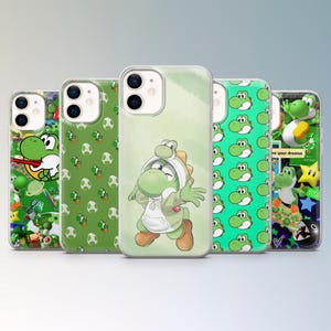 May include: A collection of five iPhone cases featuring Yoshi from the Super Mario franchise. The cases showcase various designs, including Yoshi in different poses, patterns of Yoshi eggs, and other related graphics. The cases are in shades of green, white, and brown.