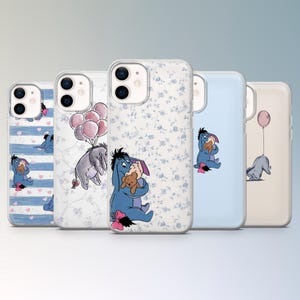 May include: Five phone cases showcasing Eeyore from Winnie the Pooh. The cases feature diverse designs, such as blue stripes, floral patterns, and Eeyore with balloons or a teddy bear. Each case has a clear, protective design.
