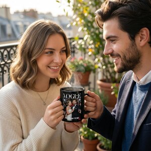 May include: Black coffee mug with the word "VOGUE" in white, featuring a photo and the text "CUSTOM TEXT". The mug is held by two people. The mug appears to be a personalized gift.
