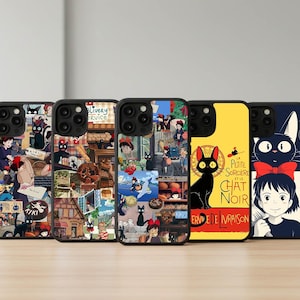 以下が含まれることがあります： アニメのキャラクターやシーンをあしらったカラフルなデザインの携帯電話ケース5つ。黒猫、若い女の子、さまざまなイラストが描かれています。ケースは黒色で光沢があります。