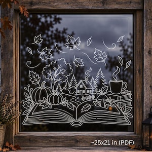 Op de afbeelding: Een witte lijnkunst raamsticker met een open boek en een landschap met pompoenen, een huis, bomen, paddenstoelen en een dampende mok. Het ontwerp bevat vallende bladeren en de tekst ~25x21 in (PDF) rechtsonder in de afbeelding.