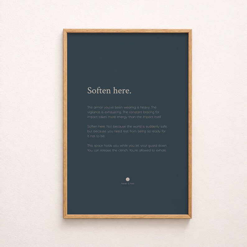 May include: A rectangular wall art print in a light wood frame featuring a dark blue background with white text that reads: Soften here. The armour you've been wearing is heavy. The vigilance is exhausting. The constant bracing for impact takes more energy than the impact itself. Soften here. Not because the world is suddenly safe, but because you need rest from being so ready for it not to be. This space holds you while you let your guard down. You can release the clench. You're allowed to exhale.