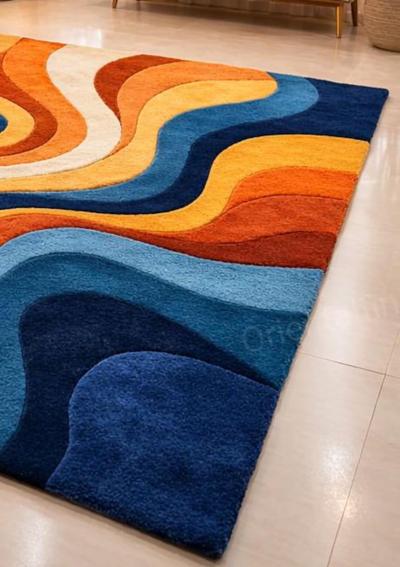 May include: A vibrant rug with a flowing, wave-like pattern in shades of orange, yellow, blue, and cream. The rug's design is a modern, abstract pattern, adding a vibrant touch to any room. The rug's design is a modern, abstract pattern.