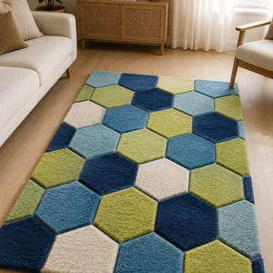 May include: A rectangular area rug featuring a geometric pattern of interlocking hexagons in shades of navy blue, light blue, lime green, and cream. The rug has a thick, textured pile construction with distinct edges between each colored hexagon shape.