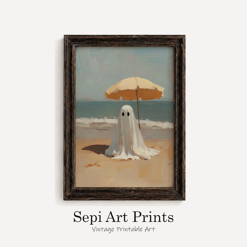 May include: A framed wall art print featuring a white ghost figure standing on a sandy beach under a yellow beach umbrella, with the ocean and sky in the background. The text Sepi Art Prints Vintage Printable Art is printed below the frame.