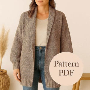 Può includere: Una donna indossa un cardigan lungo in maglia marrone con collo a scialle, abbinato a un top chiaro e jeans blu. L'immagine include una grafica circolare con il testo "Pattern PDF".