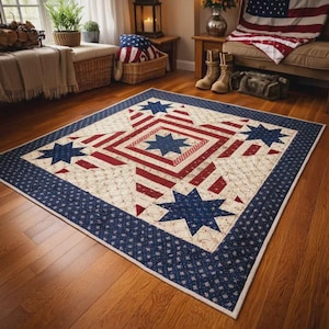 May include: A large, rectangular quilt with a patriotic theme. The quilt features a central design of a blue star within a red and white striped pattern, surrounded by blue stars and a blue patterned border. The quilt is placed on a wooden floor.