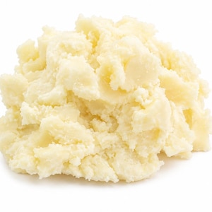 May include: A mound of creamy mashed potatoes with a pale off-white colour and a textured, uneven surface. The food item is piled into a rounded heap, showing visible peaks and valleys throughout the soft, whipped consistency of the mixture.