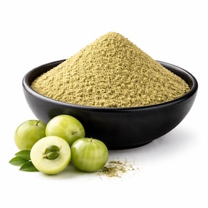 Puede incluir: Un cuenco negro lleno de un montículo de polvo verde claro, probablemente un suplemento herbal. Varias frutas verdes, algunas cortadas por la mitad, están dispuestas alrededor del cuenco, junto con algunas hojas verdes. Las frutas y el polvo sugieren un producto de salud natural.