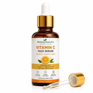 May include: A brown glass bottle of BotanyAura Co Vitamin C Face Serum with a dropper and gold cap. The label includes text and an orange slice graphic. The serum is enriched with Vitamin C, Hyaluronic Acid, Aloe Vera, and Witch Hazel. The bottle contains 30 ml.