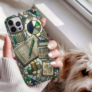 Può includere: Una custodia per smartphone con una grafica in stile vetrata che raffigura articoli da ufficio, tra cui una calcolatrice, una penna verde, un registro aperto, una cartellina con grafici e pile di monete dorate e verdi.