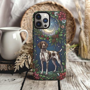 May include: A smartphone case featuring a brown and white German Shorthaired Pointer dog standing in front of a stained glass-style background with a crescent moon, stars, pine cones, holly berries, and red poinsettia flowers in a festive design.